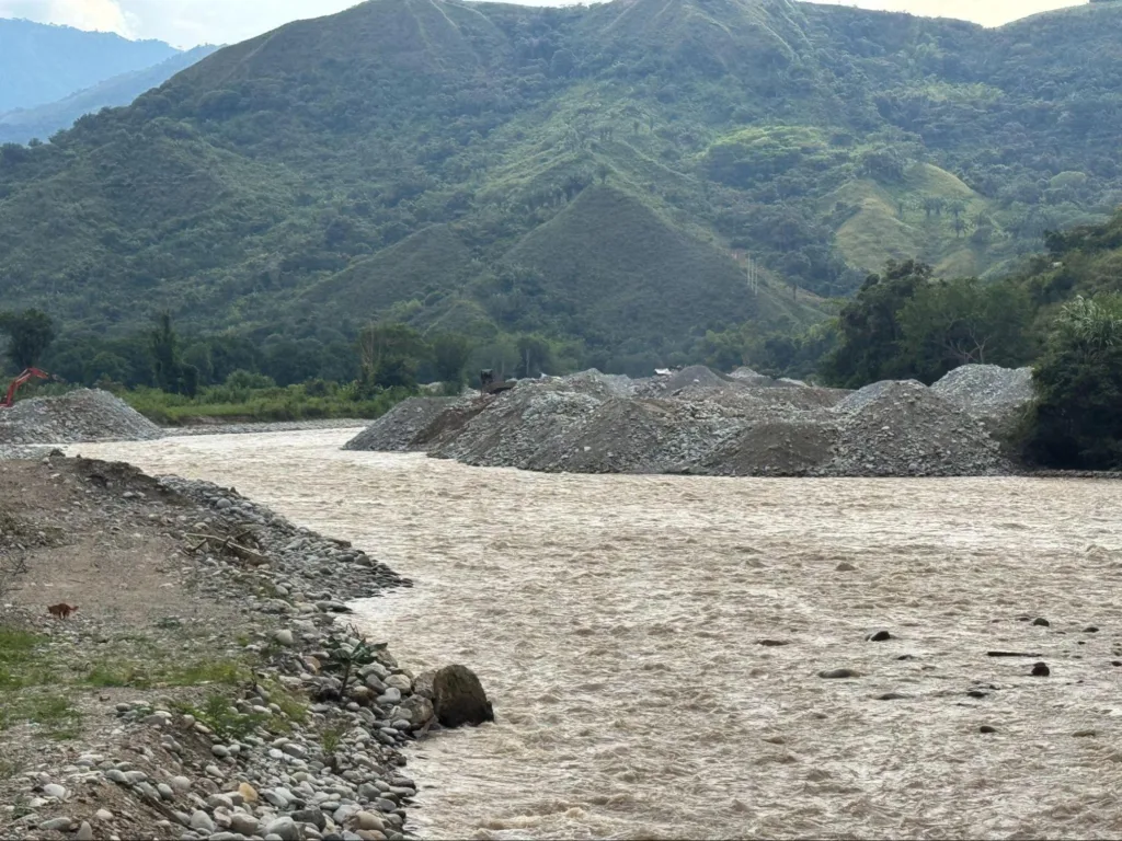 El río Saldaña, en Ataco, corre turbio y cargado de sedimento. A ambas orillas, las pilas de material removido por las retroexcavadoras dan cuenta de la magnitud de la intervención. En el fondo, maquinaria aún activa continúa la extracción sobre un cauce que ya no se reconoce. Foto tomada por Alejh Ibn Zahgui.